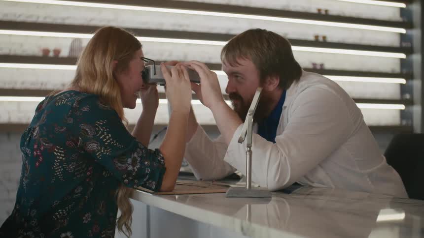 Doctor using a device that is in his patients eyes checking her vision