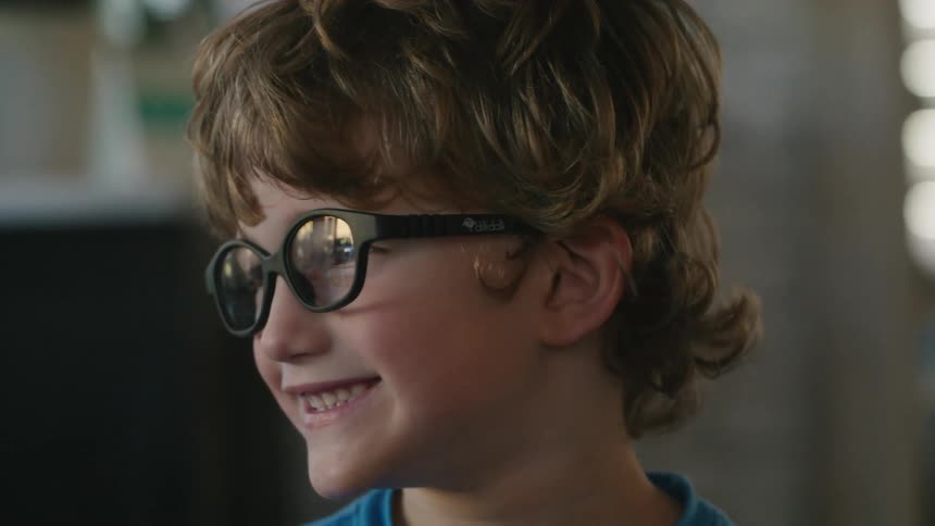 A young boy turns his head while smiling