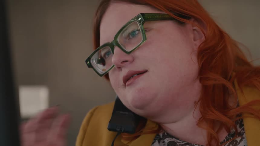 A woman ending a phone call at the office