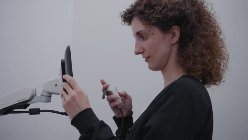 A woman is using a tablet and controller