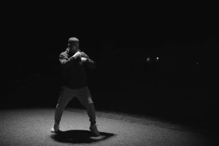 Boxer practicing outdoors under a spotlight at night