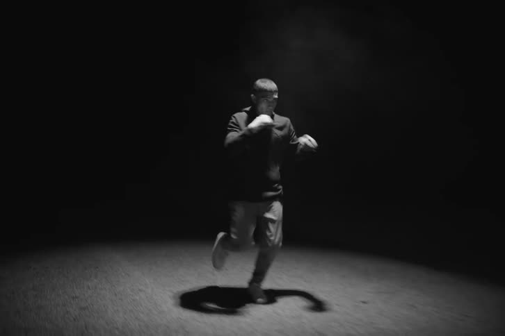 Boxer man running down the street punching the air