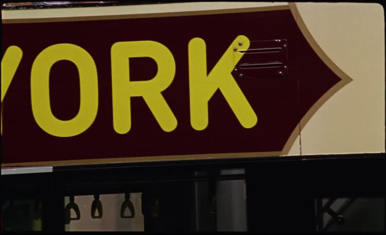 A sign reading new york on the side of a bus in the city