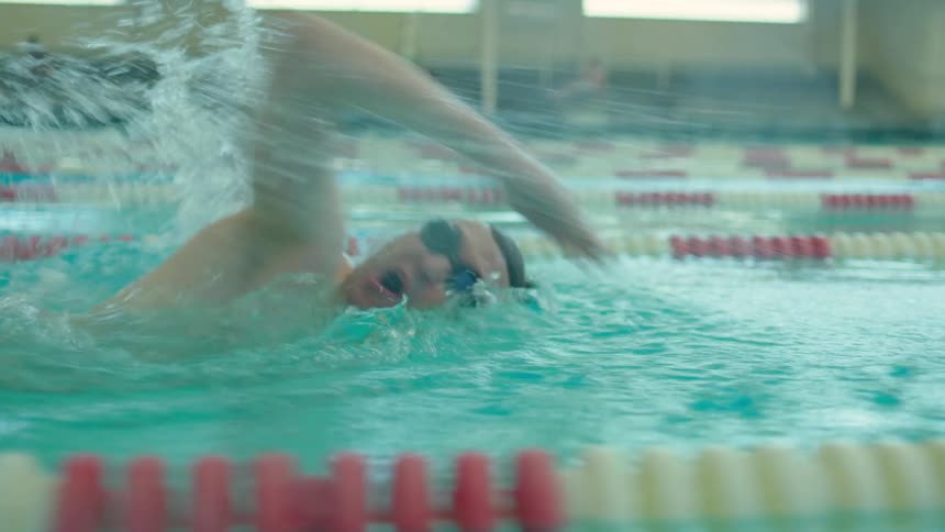Man swimming through pool lanes with arms moving