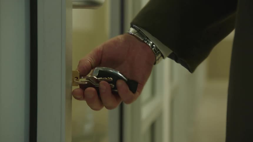 A man securely locks the door of his business
