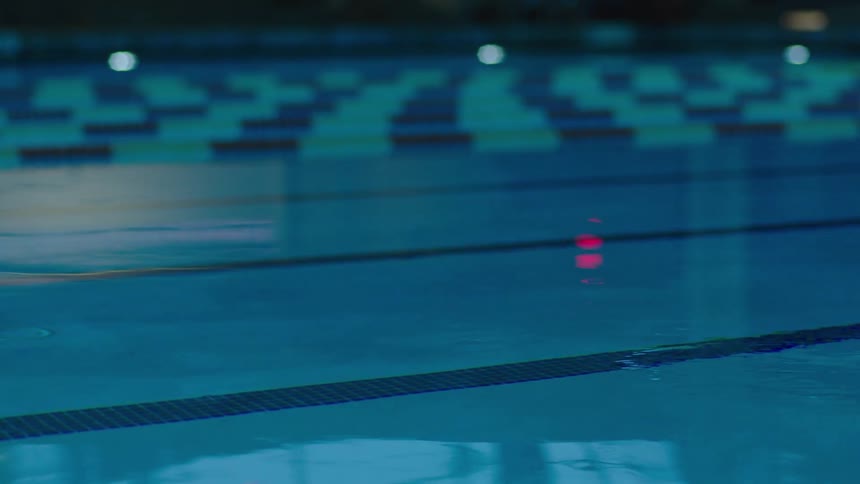 Calm water in a blue pool with divider lanes