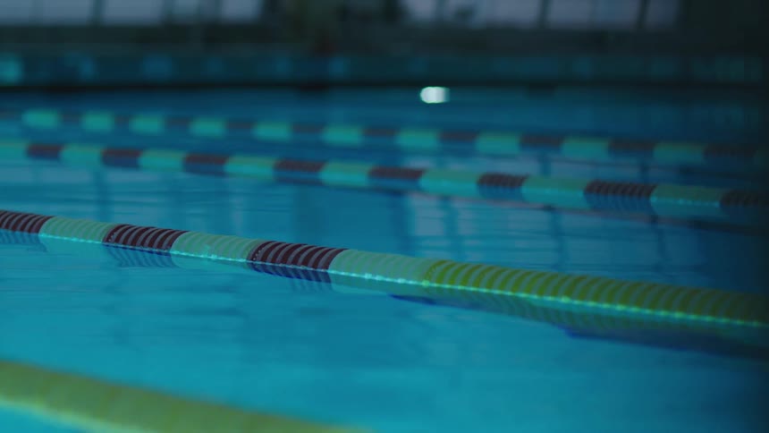 A swimming pool is filled with water and has floating lanes