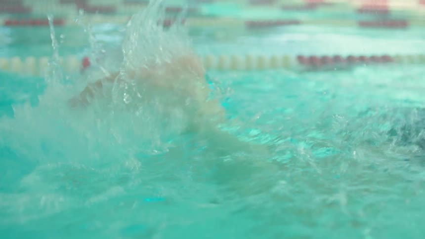 A person swims laps in a large swimming pool