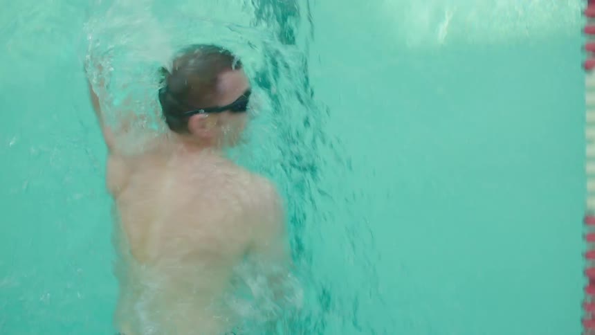 A white man swims in a pool