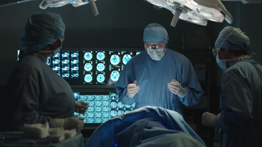 Medical staff in a lowlight room performing a surgical procedure