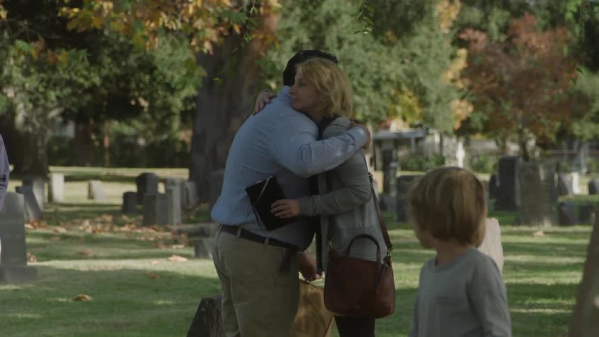 Man and woman greeting and hugging each other in a cemetery