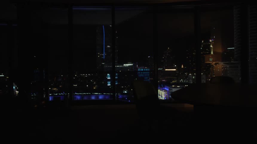 Living room of a mirrored house with a night view of a metropolis with skyscrapers