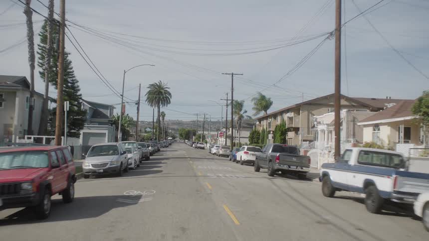 A car drives through an intersection in a suburb