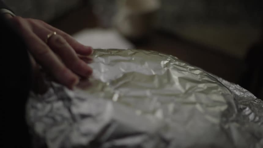 A man removes the tinfoil from a plate full of pastries