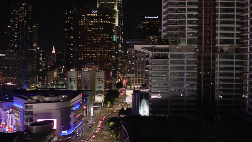 Heavy traffic drives through a dense downtown city area
