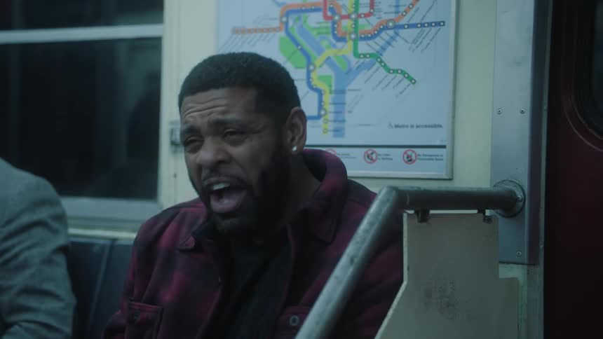 Two men laugh while riding on a subway