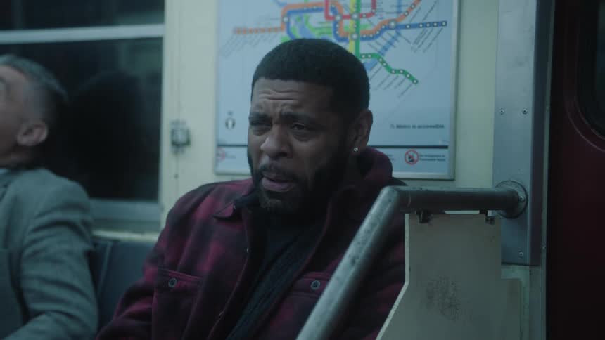 A man is laughing while sitting on the train