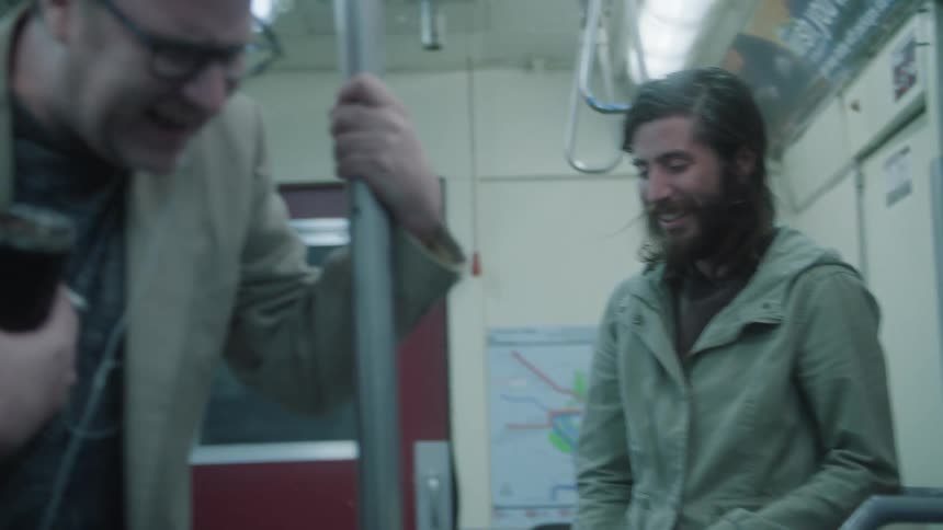 Three men are laughing on the subway