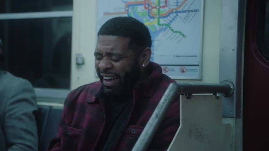 Man sitting on a train bench laughing