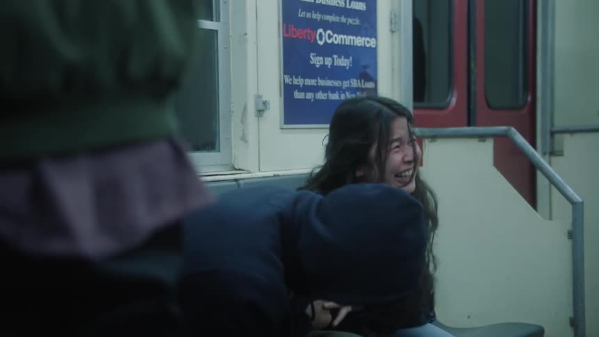 Two friends sitting on a bench while laughing