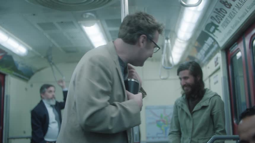 A group of men share a laugh on a subway