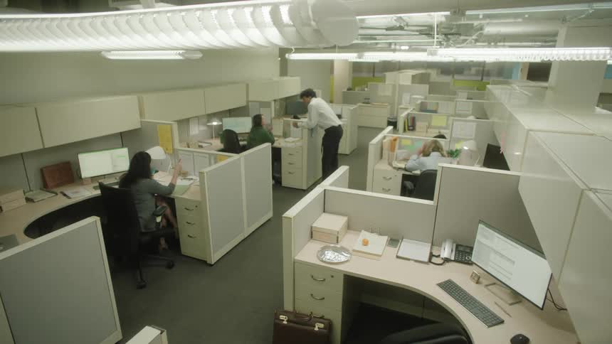 People sitting and talking in a welllit office with computers