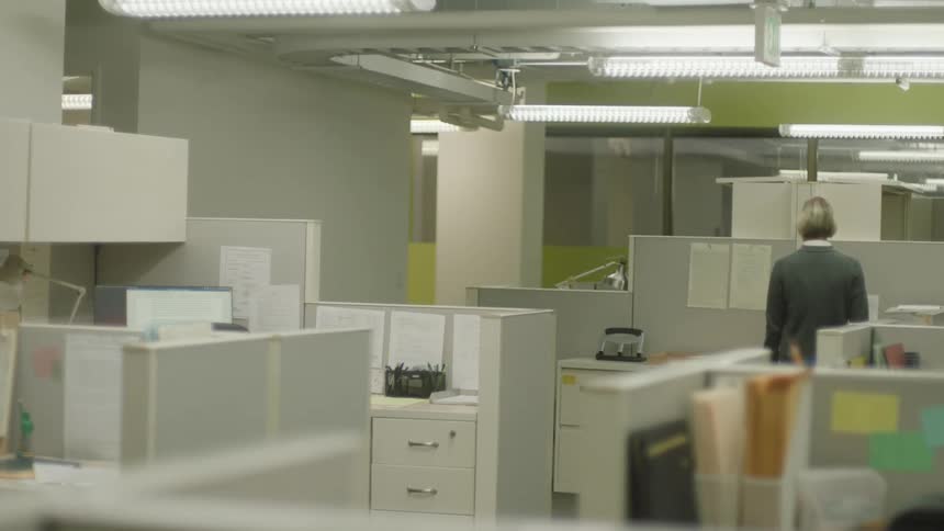 Back view of a woman walking down an office hallway