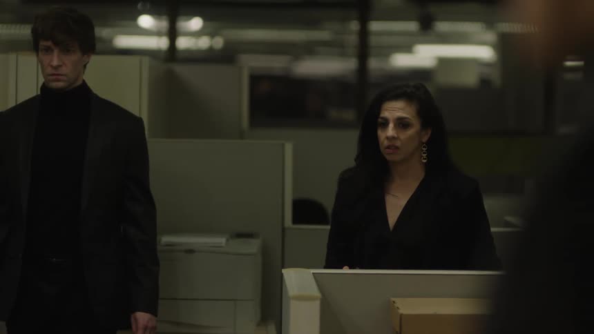 Coworkers stand by the cubicles together