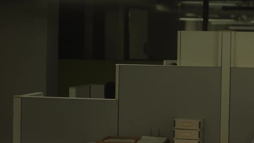 A person sits in a cubicle in an office