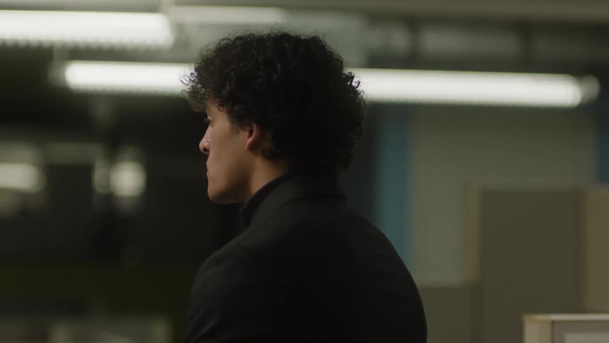 A man stands indoors thinking