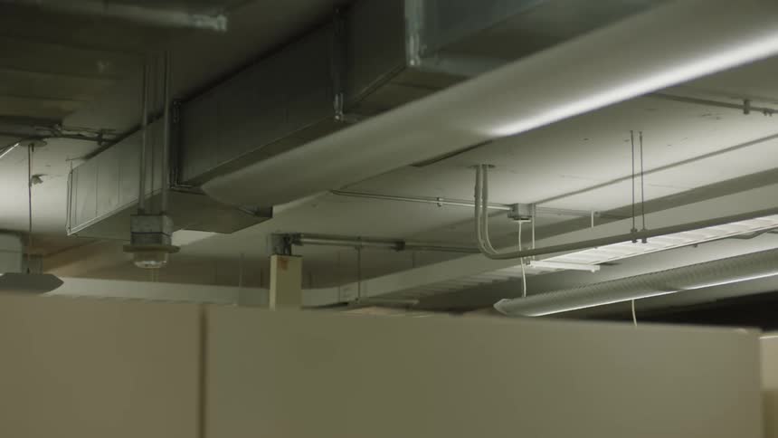 An industrial ceiling with visible ductwork and lighting fixtures