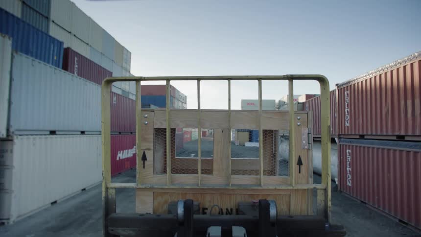 A forklift moves around a site with tanks and shipping containers