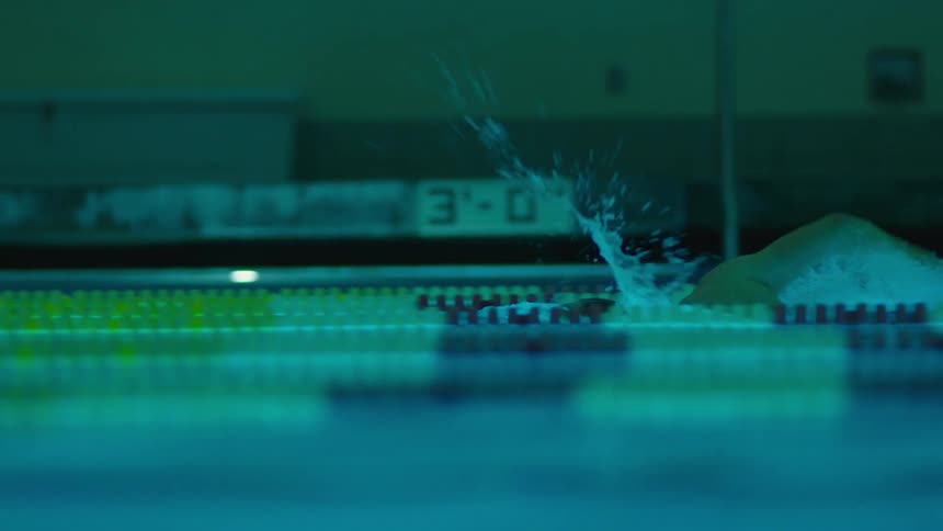A man is swimming a race in the pool