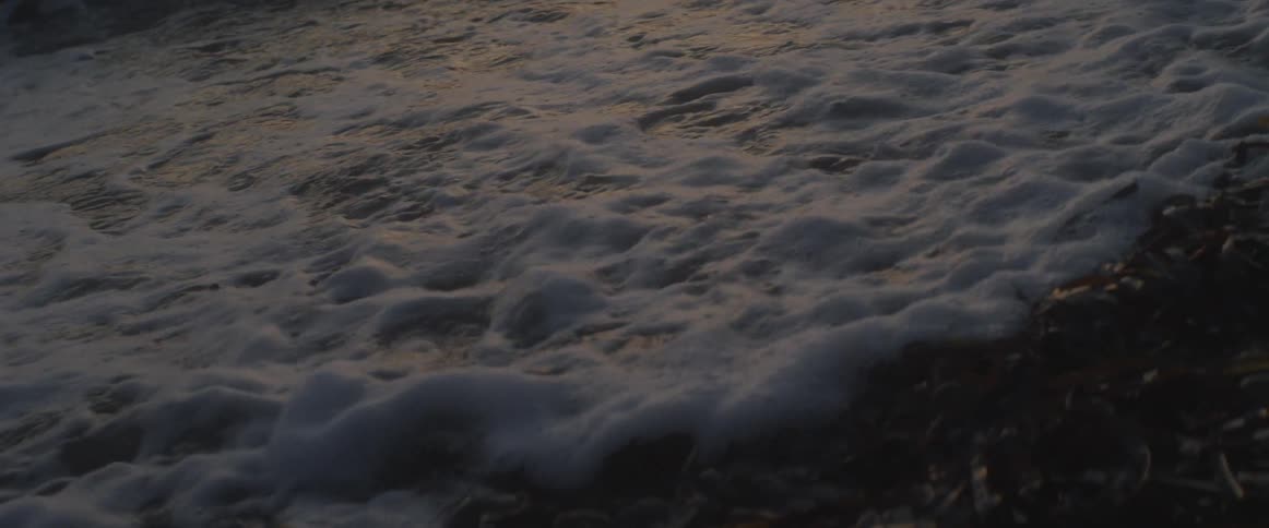 Ocean waves splashing at sunset