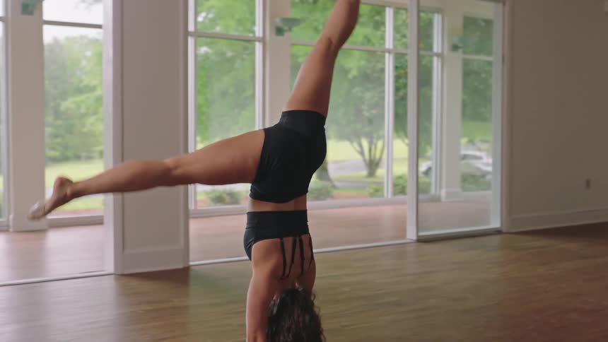 A dancer does a cartwheel while practicing in an empty room