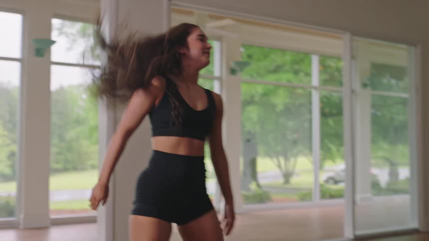 Dancer indoors doing a cartwheel jump smiling