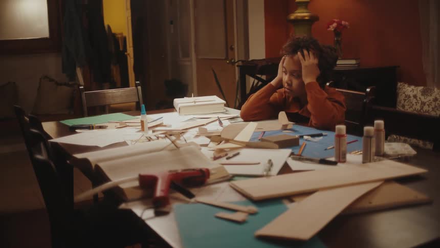 A child is working on a school project at home