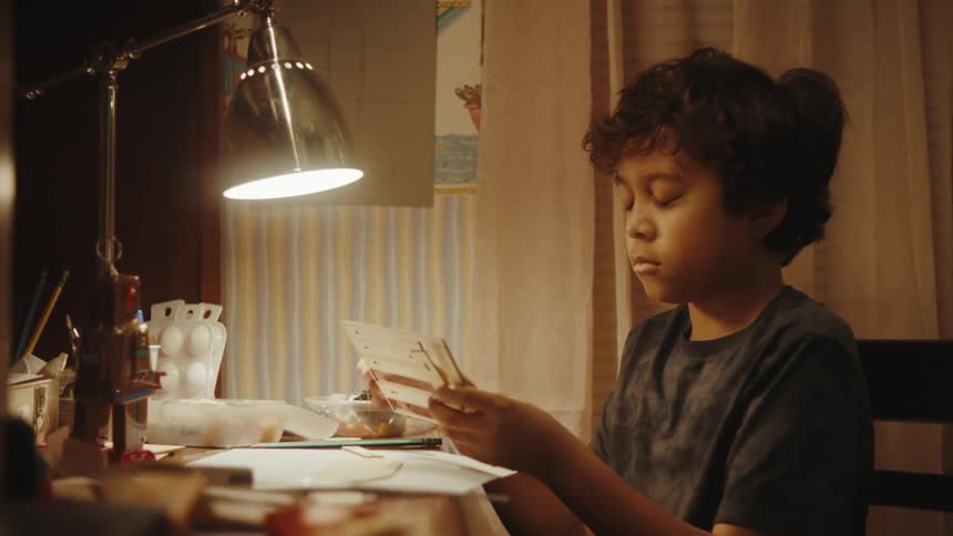 A young boy pulls pieces from a model apart