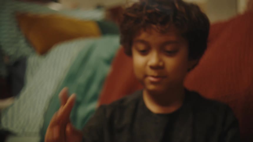 A boy playing with a pencil in the bedroom