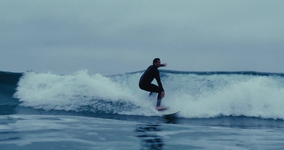 Surfer riding a wave on a cloudy day