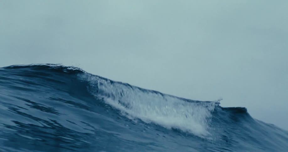 An white capped ocean wave passes over the camera