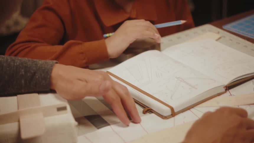 Father sitting at the table with his son while they talk with books and projects on the table
