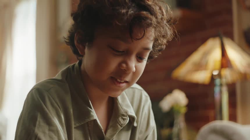 A boy sitting in the living room smiling