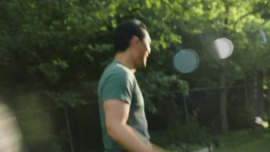 A man playing with a paper plane in the backyard