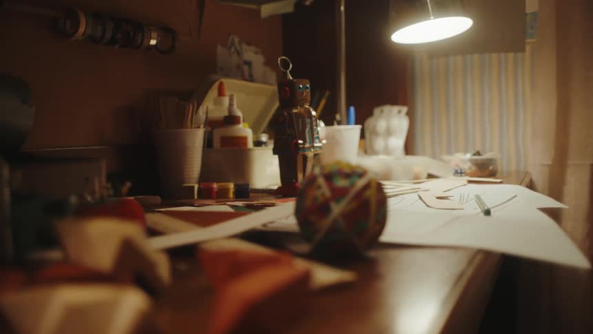 A rubber band ball is next to papers on a desk in a room