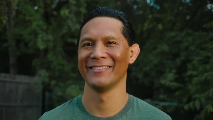 A man smiling in a backyard