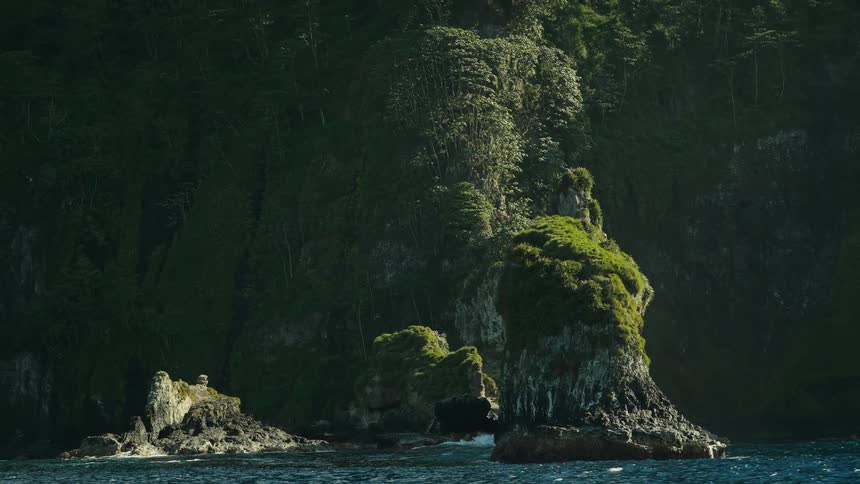 Waves crash against the mountain on the shore