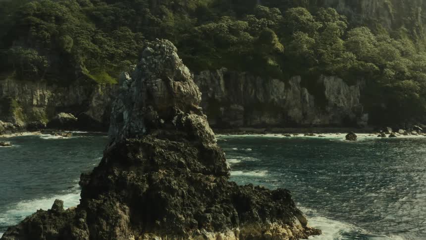 Waves pound islets near a mountainous coastline