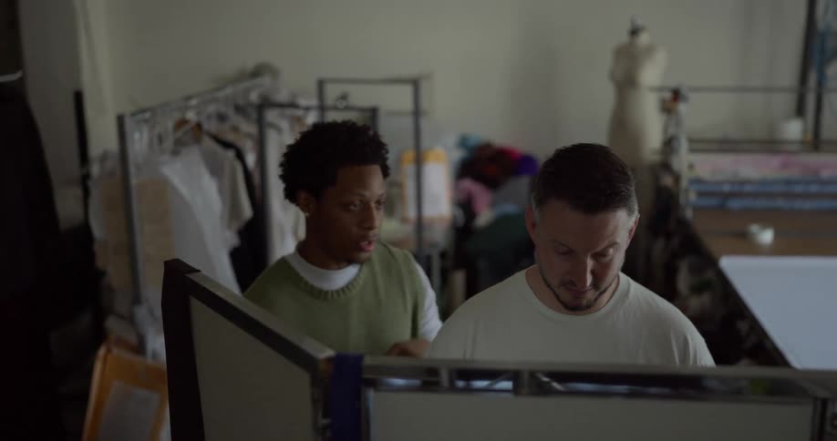 Tailor measures man standing in tshirt in workshop