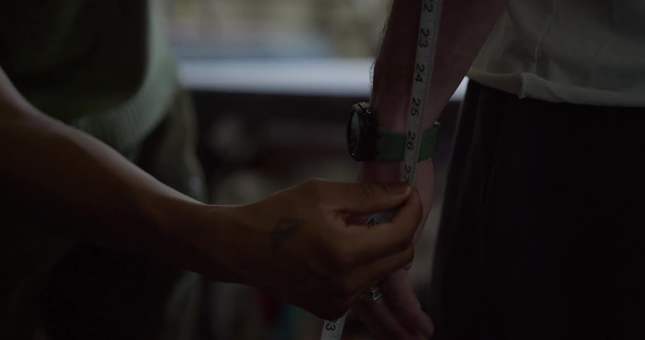 Woman measures male with a tape measure